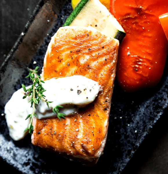 Grilled salmon with vegetables and sauce.